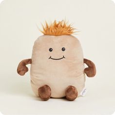 a stuffed toy with an orange mohawk on it's head and legs, sitting in front of a white background