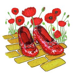 a pair of red shoes sitting on top of a wooden floor next to poppies