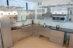 a modern kitchen with stainless steel appliances and wood flooring