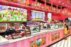 the inside of a candy shop with people standing at the counter and looking in to the cash register