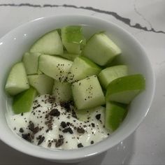 a white bowl filled with cucumber and yogurt on top of a table