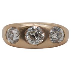 an antique three stone ring in yellow gold with two round diamonds on the side and four smaller stones at the top