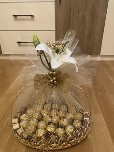 a basket filled with chocolates and flowers on top of a wooden floor