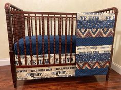 a baby crib with a blue and white quilt on it's bedding