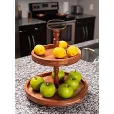 three tiered tray with apples and lemons on it in a kitchen countertop