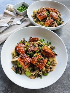 two white bowls filled with food on top of a table