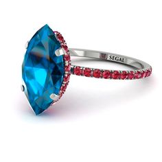 a blue ring with red and white stones on the sides, set in 18k white gold