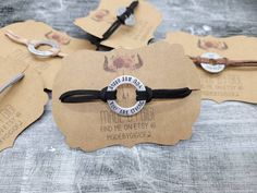 four pieces of brown paper with black string and metal clasps attached to each other