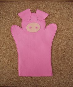 a pink felt pig with ears sticking out of it's back pocket on a cork board