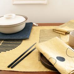 a table topped with a bowl and two chopsticks