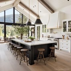 a large kitchen with lots of counter space and stools in it's center island