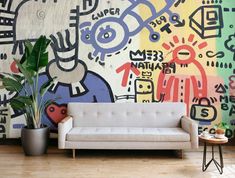 a white couch sitting in front of a colorful wall