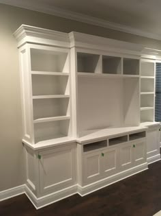 an empty room with built in bookshelves and cabinets