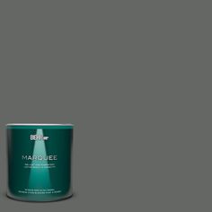 a can of behr marquee paint on a green background