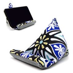 a cell phone sitting on top of a blue and white flowered pillow next to a wallet