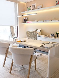 a white desk with chairs and a computer on it