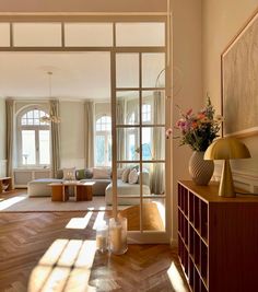 an open living room with wooden floors and large windows