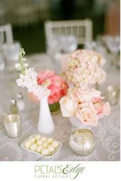 a table topped with vases filled with flowers and candy