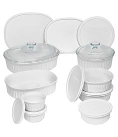 a set of white dishes with lids and plates on the top one has a glass lid