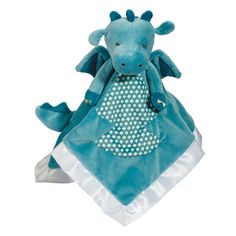 a blue dragon stuffed animal sitting on top of a blanket