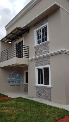 the front of a two story house with a balcony and balconies on each floor