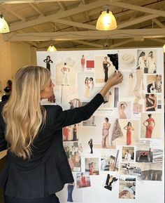 a woman standing in front of a white board with pictures on it's side