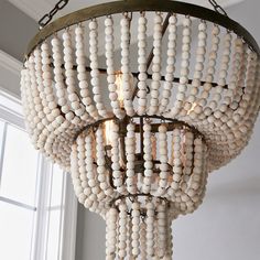 a chandelier made out of white beads hanging from a ceiling in a room