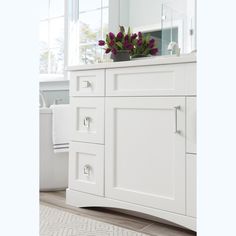 a white bathroom vanity with flowers on top