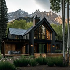 a house in the woods with mountains in the background