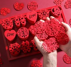 a person is holding some red hearts in front of a large number of smaller ones