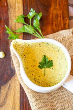 a white bowl filled with broccoli soup and garnished with parsley