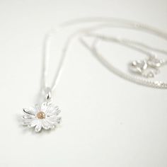 A beautifully designed 925 Sterling Silver Daisy Pendant with a Gold Plate stamen in the centre. The daisy is the April birth flower but also represents innocence, purity and new beginnings, which is why they are often gifted to new mothers or as gift for children.Choose which chain length you would prefer from the drop down menu. A lovely gift for family or friends or maybe something nice for yourself.Your purchase will arrive in a organza gift pouch but if you would like a luxury ribboned box, Dainty Daisy Sterling Silver Jewelry, Silver Daisy Jewelry Gift, Silver Daisy Jewelry For Gift, Dainty Daisy Silver Jewelry, Sterling Silver Daisy Jewelry With Flower Charm, Sterling Silver Daisy Flower Charm Jewelry, Delicate Sterling Silver Birth Flower Necklace, Mother's Day Sterling Silver Flower Necklace, Sterling Silver White Gold Flower Necklace