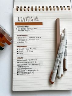 a notepad with some writing on it next to two markers and a pen that says leviius