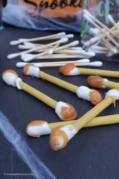 several yellow and white marshmallows are on a table with toothpicks