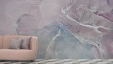 a couch sitting in front of a wall with a painting on it's side