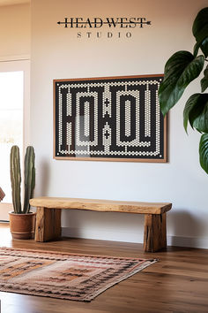 a wooden bench sitting next to a potted plant on top of a hard wood floor