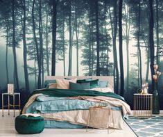 a bed room with a neatly made bed next to a forest wall mural on the wall