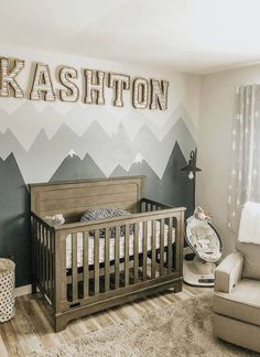 a baby's room with mountains painted on the wall and a crib in the corner