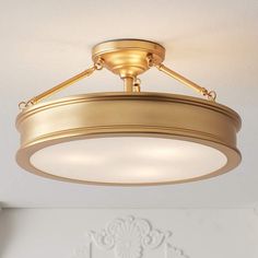 a light fixture in a white room with a ceiling fan and chandelier hanging from the ceiling