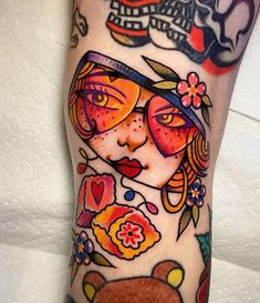 a woman's leg with tattoos on it and a teddy bear in the foreground