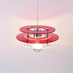 a red light hanging from a ceiling with a white wall in the background and two circular lights on each side