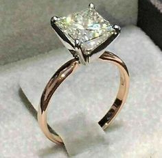 an engagement ring with a princess cut diamond on it's side in a box