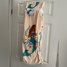 a towel hanging on a door handle next to a white door with an image of a mermaid