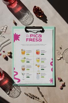 a menu sitting on top of a table next to wine glasses and other items in front of it