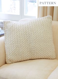 a white pillow sitting on top of a couch