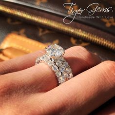 a close up of a person's hand with a diamond ring on their finger