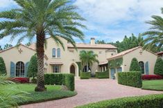 a large house with lots of trees and bushes around the front entrance to it is surrounded by greenery