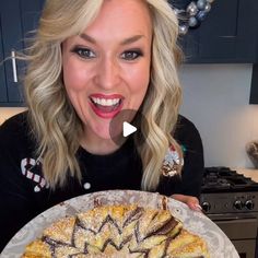 a woman is smiling while holding up a pie in front of her face and looking at the camera