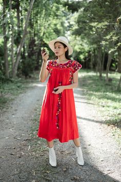 "Vintage Mexican Oaxaca dress with florals embroidered. Short sleeves with colorful floral hand embroidery throughout. Red cotton material. Tailored chest with crochet lace trim and little people on smocking. Condition: In very good vintage condition just a small stain and white spot on hips area Measurements (Inch) size estimate: M *Measurements are taken in inches with the garment laying flat. BUST: 42 \" HIPS: 70 \" FULL LENGTH: 44 \" SLEEVE LENGTH: 4.5 \" shoulder to shoulder : 15 \" Our mod Red Folk Style Embroidered Dress, Red Floral Embroidered Summer Dress, Traditional Red Embroidered Spring Dress, Red Folk Embroidered Dress With Floral Design, Red Floral Embroidered Dress For Summer, Red Folk Style Dress With Floral Embroidery, Red Folk Style Dress With Embroidered Hem, Folk Style Red Dress With Embroidered Hem, Traditional Red Embroidered Dress For Spring