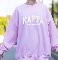 Soft, cute, and trendy, this Kappa Kappa Gamma Sorority varsity crewneck sweatshirt will quickly become your go-to cozy KKG crewneck sweatshirt! Available in Brown, Light Tan, Light Blue, and Light Pink colorways. We print on high quality, soft, cozy materials, sustainably made and printed in the US. ♥ SIZING ♥ Unisex Sizing- For a more feminine, fitted look we recommend getting your size. For a more oversized look, we recommend sizing up. ♥ SHIP TIME ♥ Items may take up to 7 business days to process before shipping. Shipping time is (on average) an ADDITIONAL 2-5 business days. Shipping times vary for many reasons, but is largely influenced by your location. ♥ CARE INSTRUCTIONS ♥ Wash garments inside-out, with similar colors. Tumble dry on a low cycle. Hang-dry for longer life. Do NOT iro Local Optimist, Varsity Crewneck, Sigma Kappa Sorority, Alpha Phi Sorority, Delta Zeta Sorority, Kappa Delta Sorority, College Crewneck, Theta Phi Alpha, Delta Sorority